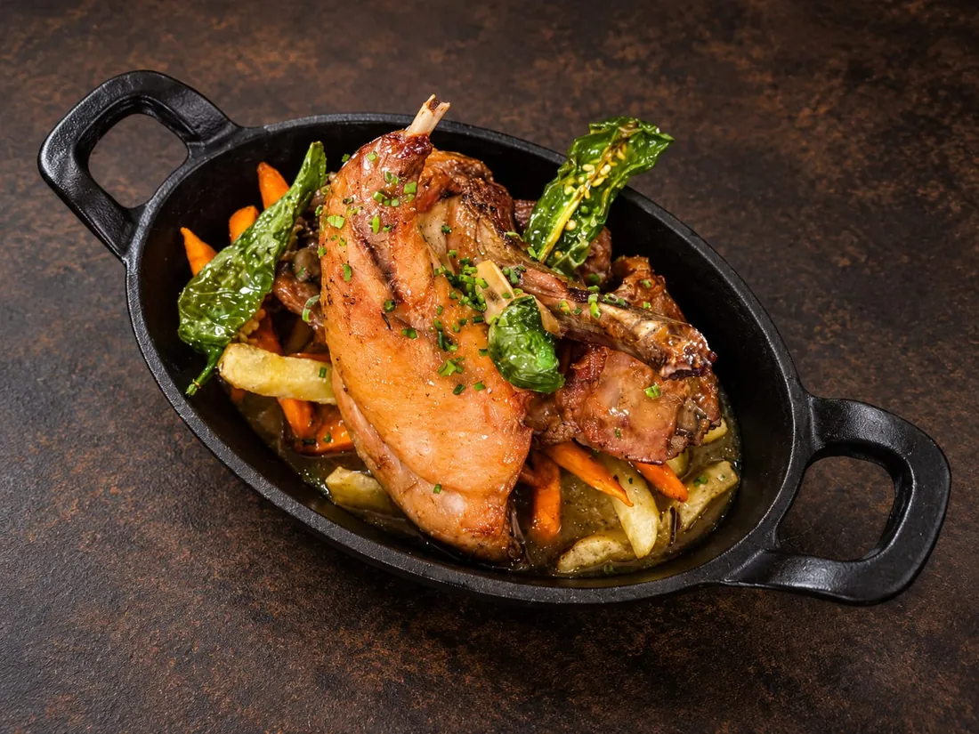 Asado dorado en cazuela de hierro con patatas, zanahorias y pimientos